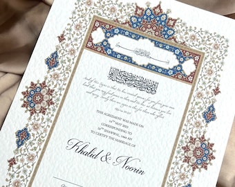 May include: A white Islamic marriage certificate with ornate floral borders in shades of blue, red, and gold. The text reads "This agreement was made on 14th May 2023, corresponding to 24th Shawwal, 1444 AH to certify the marriage of Khalid & Noorin."