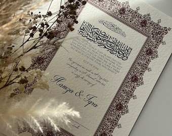 May include: A white card with a decorative border in a maroon colour. The card features a passage from the Quran in Arabic script. The text below the Arabic script reads "This agreement was made on April 7th, 2023 corresponding to 24th Shawwal, 1444 AH to certify the marriage of Hamza & Iqra".