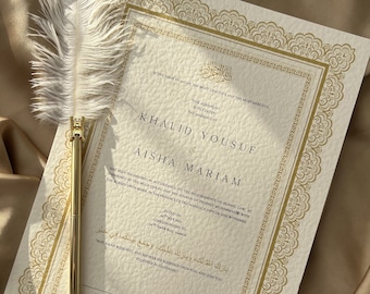 May include: A white card with gold calligraphy and ornate borders announcing the marriage of Khalid Yousuf and Aisha Mariam. The card is dated May 2023 and includes an Arabic blessing.