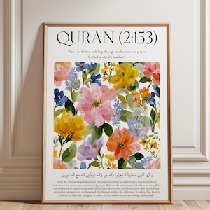 May include: A framed floral art print featuring a watercolor design of colorful flowers in pink, yellow, blue, and orange. The print includes the text "QURAN (2:153)" and a quote. The artwork is displayed in a wooden frame.