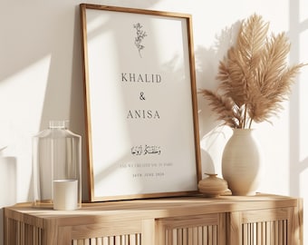 Peut inclure: Une impression encadrée avec un design minimaliste mettant en vedette les noms Khalid & Anisa, une petite illustration florale et le texte arabe "وَخَلَقْنَاكُمْ أَزْوَاجًا" qui se traduit par "Et Nous vous avons créés en couples." L'impression comprend également la date "18 juin 2024".