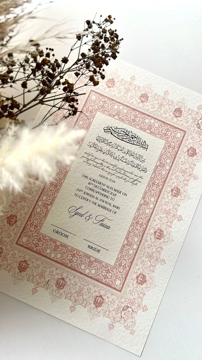 Pode incluir: Um certificado de casamento isl&acirc;mico rosa e branco com desenhos florais ornamentados. O texto diz "Este acordo foi feito em 18 de dezembro de 2021 correspondente ao 24 de Jumada al-Awwal 1443H para certificar o casamento de Syed & Faiza. Noivo Noiva."