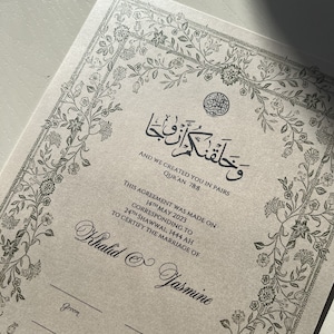 Op de afbeelding: Een beige huwelijkscertificaat met een decoratieve bloemrand. Bovenaan staat de tekst "En Wij hebben jullie in paren geschapen, Koran 78:8". Het certificaat is gedateerd 14 mei 2023 en certificeert het huwelijk van Khalid en Jasmine.