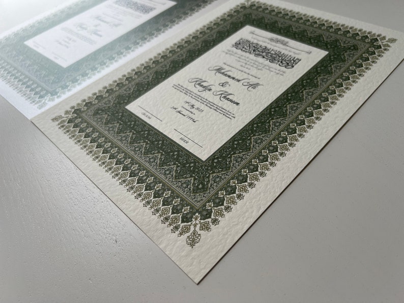 Peut inclure: Un certificat de mariage blanc avec une bordure verte orn&eacute;e d'un motif g&eacute;om&eacute;trique complexe. Le certificat indique "Muhammad Ali & Khadija Khanum" et la date "14 juillet 2013 (1er Jamadi 1434)".