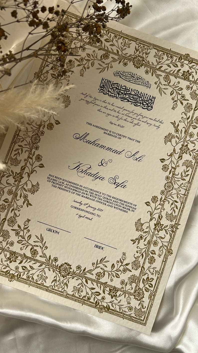 May include: A cream-coloured marriage certificate with gold floral borders and Arabic text. The text reads "This agreement is to certify that the marriage of Muhammad Ali & Khadija Safa has been solemnised in accordance to the requirements of Islamic law, as enshrined in the Holy Quran and the Sunnah of Prophet Muhammad (SAW) with the agreed upon mahr, in the presence of the marriage officer and witnesses. Saturday 15th January 2029, corresponding to Rajab 1450h."
