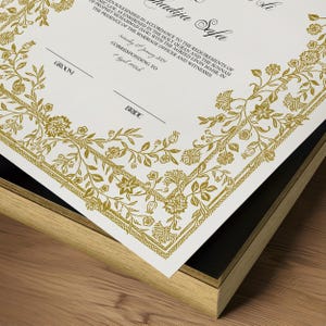 Może przedstawiać: Biały akt ślubu z złotymi kwiatowymi obramowaniami i tekstem "Solemnized in accordance to the requirements of Islamic Law, as enshrined in the Holy Quran and the Sunnah of Prophet Muhammad (SAW) with the agreed upon mahr, in the presence of the Marriage Officer and Witnesses. Saturday 18 January 2024. Corresponding to 7  Jumada al-Ula 1445."