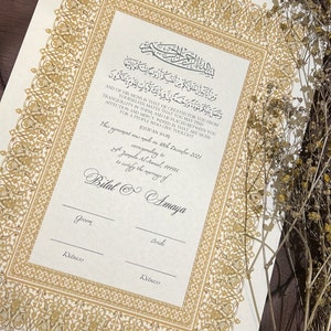 Peut inclure: Un document blanc avec une bordure dor&eacute;e et du texte arabe. Le document est un certificat de mariage pour Bilal et Amaya, dat&eacute; du 18 d&eacute;cembre 2021.