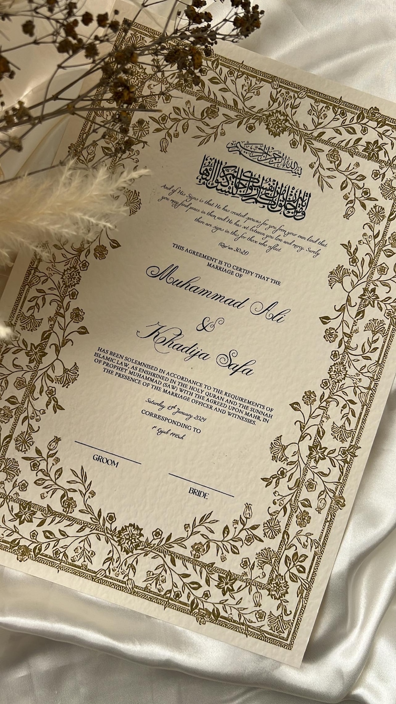 Może przedstawiać: Tradycyjny islamski akt ślubu z złotymi wzorami kwiatowymi i tekstem "Niniejsza umowa poświadcza, że ​​ślub Muhammada Alego i Khadiji Safa został zawarty zgodnie z wymogami prawa islamskiego, zgodnie z tym, co zostało ustanowione w Świętym Koranie i Sunnie Proroka Muhammada (SAW) z ustalonym mahre, w obecności urzędnika ślubnego i świadk&oacute;w. Sobota, 1 stycznia 2021 r., odpowiadająca 1 Jumad 1443h."