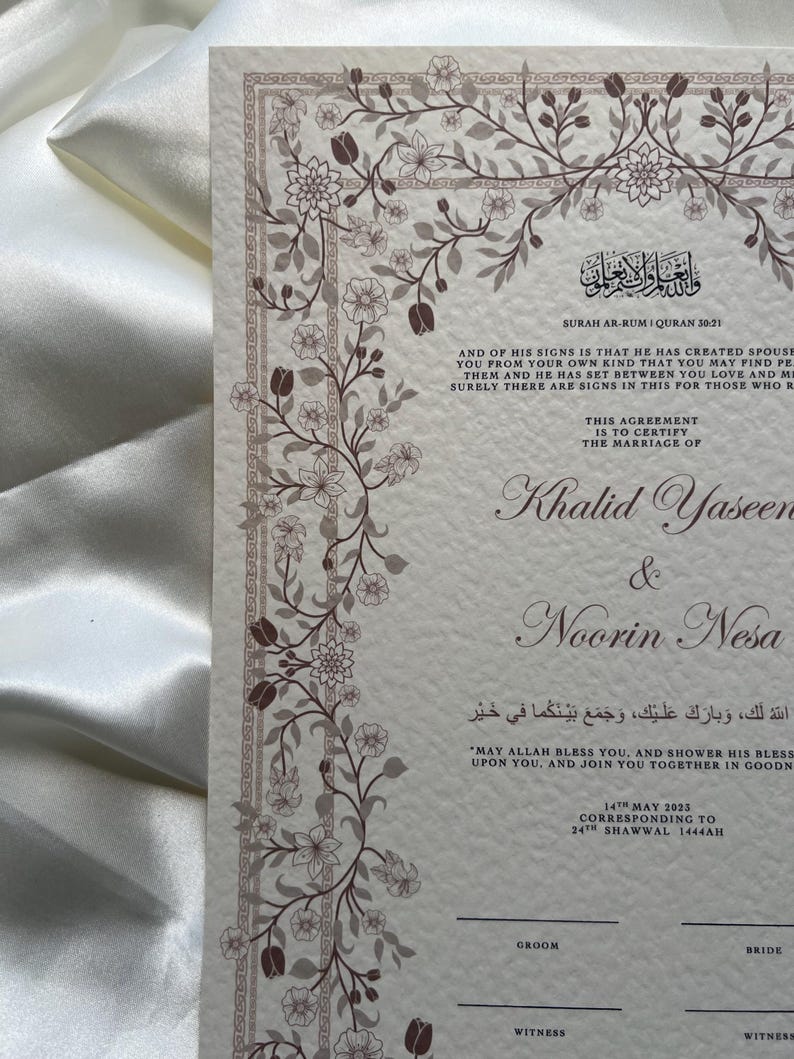 Puede incluir: Un certificado de boda con un dise&ntilde;o de borde floral. El documento presenta texto en ingl&eacute;s y &aacute;rabe, incluyendo nombres, fechas y vers&iacute;culos religiosos. La paleta de colores incluye crema, marr&oacute;n y blanco.