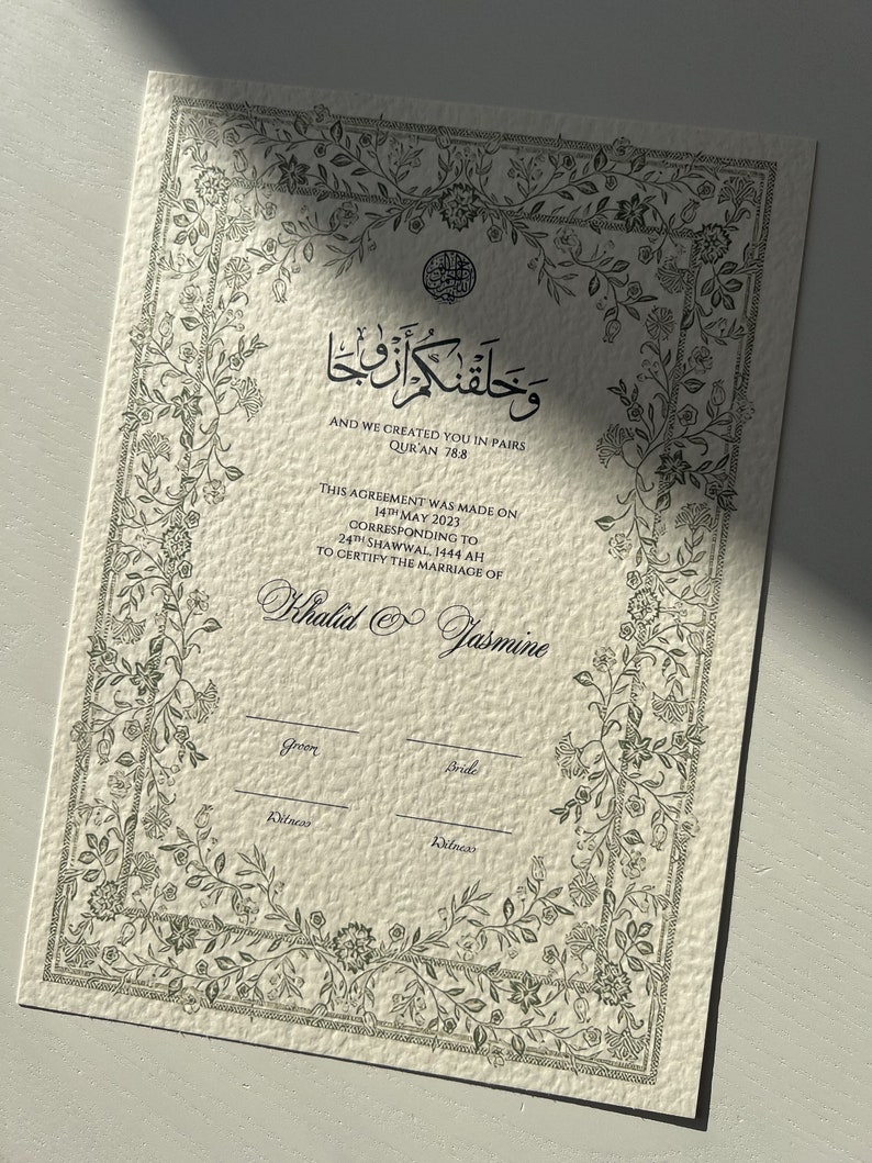 Op de afbeelding: Een wit certificaat met een zwarte bloemmotiefrand en tekst. De tekst luidt "En Wij hebben jullie in paren geschapen, Koran 78:8." Het certificaat is voor het huwelijk van Khalid en Jasmine. De datum van de overeenkomst is 14 mei 2023, overeenkomend met 24 Shawwal 1444 AH.