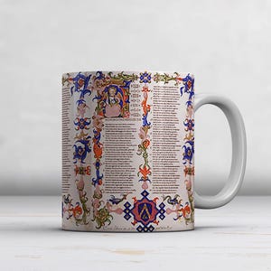 May include: White ceramic mug featuring a detailed, colorful medieval manuscript design. The design includes ornate borders, illustrations, and text in a vintage style. The mug has a white handle and is set against a neutral background.