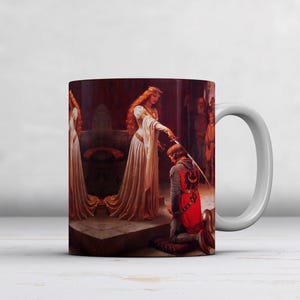 May include: White ceramic mug featuring a historical painting of a woman in a white gown handing a sword to a kneeling knight. The artwork depicts a coronation scene with rich colors and detailed figures. The mug has a white handle.