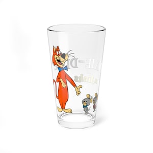 May include: A clear glass featuring a cartoon image of Dixie and the Dixie Friends. The cartoon cat is orange with a blue bow tie. Two gray mice are also featured on the glass. The text "Dixie and the Dixie Friends" is printed on the glass.