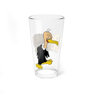 May include: A clear glass featuring a cartoon vulture character with a yellow beak and feet, and black and white feathers. The glass has the words "Golden Eagle" printed on it. The glass is empty.