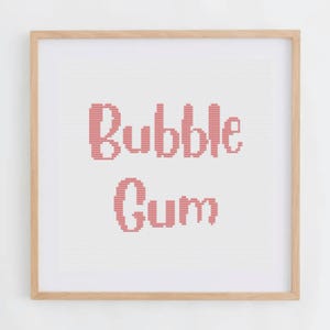 Könnte beinhalten: Ein gerahmtes Kreuzstichbild mit den Worten "Bubble Gum" in rosafarbenem Garn auf weißem Hintergrund.