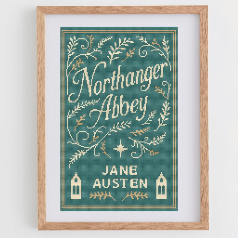 May include: Framed cross-stitch art featuring the book cover of "Northanger Abbey" by Jane Austen. The design is on a teal background with cream-colored text and floral accents. The artwork is in a wooden frame.