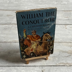 May include: A vintage Ladybird book titled "William the Conqueror: An Adventure from History". The cover features an illustration of William the Conqueror on horseback, leading an army of soldiers.