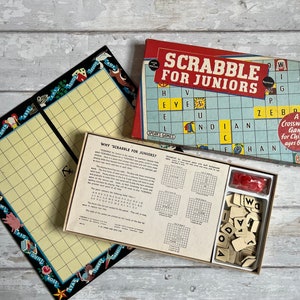 May include: A vintage Scrabble board game for juniors, featuring a blue and white game board with the words "Scrabble for Juniors" printed on the box. The game includes letter tiles, a score sheet, and instructions.