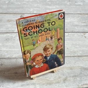 May include: A vintage Ladybird book titled "Going to School" with a red cover and a ladybug logo. The book features an illustration of children walking to school.