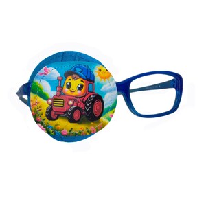 Könnte beinhalten: Ein blaues Augenpflaster mit einem Cartoon-Bild eines Kindes, das einen roten Traktor fährt. Das Pflaster ist an einer blauen Brille befestigt.
