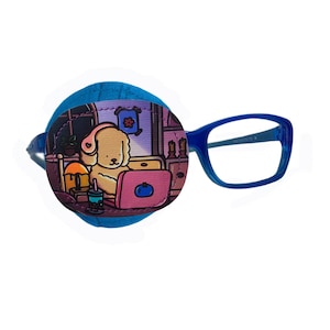 Könnte beinhalten: Ein blaues Augenpflaster mit einer Cartoon-Illustration eines Hundes, der Kopfhörer trägt und einen Laptop benutzt. Der Hund sitzt in einem Raum mit einem Bett, einer Pflanze und einem Nachttisch. Das Augenpflaster ist an einer blauen Brille befestigt.