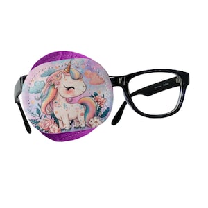 May include: Purple eye patch with a unicorn design. The unicorn is white with a rainbow mane and tail. It is surrounded by flowers and clouds. The eye patch is attached to a pair of black eyeglasses.