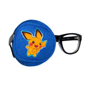 Może przedstawiać: Niebieski łatkę na oko z żółtym postacią Pikachu. Łatka na oko jest przymocowana do czarnych okularów.