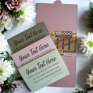 Könnte beinhalten: Papeterie-Set mit drei Karten in Salbeigrün, Rosa und Grau, jeweils mit dem Text "Your Text Here". Ein Lotterielos ist in einem rosa Umschlag sichtbar. Blumenschmuck umgibt die Artikel.