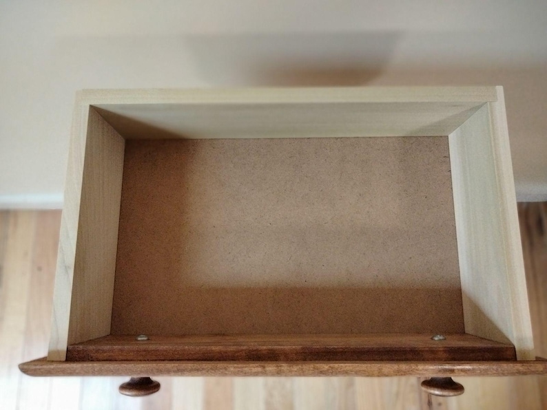 May include: Empty wooden drawer with a light brown interior. The drawer is open and the inside is visible.