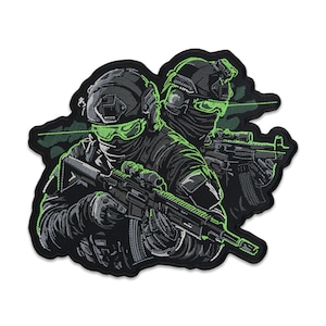 May include: Embroidered patch featuring two soldiers in tactical gear, holding rifles. The design uses shades of black, gray, and green, with neon green accents on the visors and camouflage details. The patch has a unique shape.