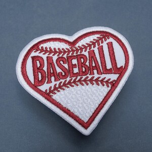 May include: Heart-shaped baseball patch with the word "BASEBALL" in red, stitched onto a white background. The patch has a red border and baseball stitching details, ideal for sports fans.
