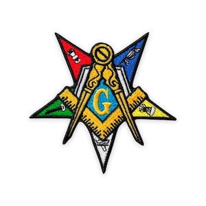 Op de afbeelding: Geborduurde patch met een gouden passer en winkelhaak, met een blauwe "G" in het midden. Het ontwerp is geplaatst in een stervorm met meerdere punten met rode, blauwe, groene en gele segmenten. De patch heeft een zwarte rand.