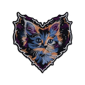 以下が含まれることがあります： ハート型の刺繍ワッペンで、三毛猫の顔が描かれています。猫は青、オレンジ、黒の毛並みで、大きな目をしています。ワッペンは白と黒の糸で縁取られており、耳の周りには小さな白い点が散りばめられています。
