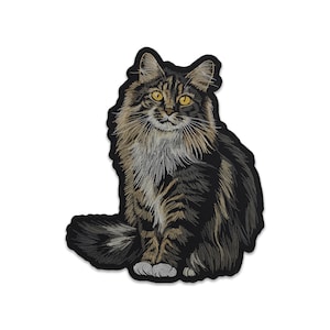 May include: Embroidered patch featuring a detailed illustration of a Maine Coon cat. The cat has brown and black striped fur, yellow eyes, and a fluffy mane. The patch is black around the edges and is designed to be ironed on or sewn.