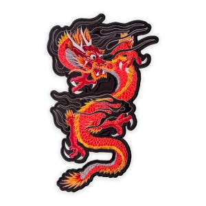 Puede incluir: Parche bordado con un dragón rojo y amarillo con detalles intrincados. El dragón tiene una expresión feroz y está rodeado de humo negro estilizado. El parche está diseñado para su aplicación en ropa o accesorios.