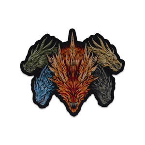 May include: An embroidered patch featuring five dragon heads arranged in a fan shape. The central head is bright orange and red, flanked by heads in olive green, light blue, metallic gold, and dark grey, all outlined with a thick black border.
