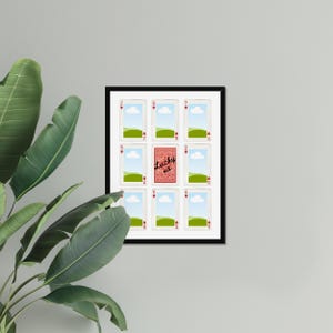 May include: A framed artwork featuring playing cards. The central card is red and reads "Lucky us." The other cards are white with red hearts, green fields, and blue skies. The frame is black.