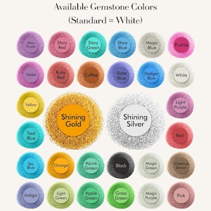 May include: A chart displaying a variety of gemstone colors, including Starry Purple, Red, and Green, along with options like Shining Gold and Silver. The text at the top reads "Available Gemstone Colors (Standard = White)".