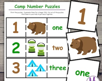 Op de afbeelding: Een printbaar educatief spel met de titel "Camp Number Puzzles" met de tekst "Camping #1-12 Puzzles". Het spel bevat cijferpuzzels met illustraties met campingthema, waaronder een beer, lantaarns en tenten. De cijfers en woorden zijn bruin en groen.