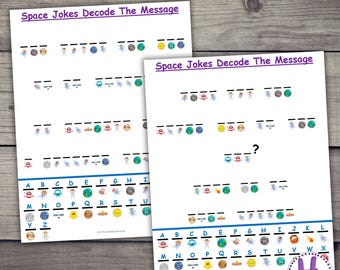 May include: Two white sheets of paper with the text "SPACE JOKE SECRET MESSAGES" and "Space Jokes Decode The Message". The sheets contain a coded message with space-themed illustrations and an alphabet key at the bottom. The sheets are on a wooden surface.