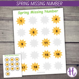 May include: A white worksheet with the text "Spring Missing Number" and sun graphics with numbers 1-18. A smaller sheet with numbers 2-20 is also present. The background is a wooden surface.