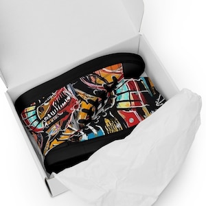 May include: A pair of black high-top canvas shoes with colorful abstract art printed on the sides. The shoes are in a white box with tissue paper.