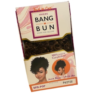 May include: A box of Vivica's Bang N Bun hair extensions. The box is white, pink, and gold with the text "Two in One!" and "Hump for Volume." The product is 100% premium Kanekalon. The style/color is BPB-POP, P4/27/30.