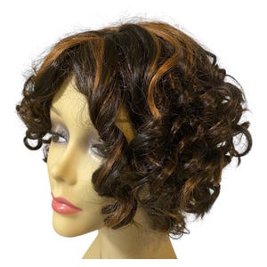 May include: A short, curly wig featuring a dark brown base color with prominent copper-toned highlights throughout. The hair is styled in loose, voluminous curls that frame the face, displayed on a neutral-toned mannequin head with defined features.