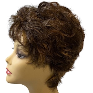 May include: A short, layered wig with a mix of brown and auburn tones. The wig has a natural-looking style with textured waves and highlights, designed for a realistic appearance. The wig is displayed on a mannequin head.