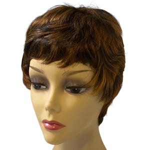 May include: A short, layered wig with a mix of brown and auburn tones. The wig is styled with a slight wave and a side part. The wig is on a mannequin head with a neutral skin tone and makeup.