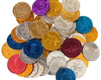 Könnte beinhalten: Eine Ansammlung farbenfroher, metallischer Münzen mit verschiedenen Designs und Texten. Die Münzen sind in Gold-, Silber-, Rot-, Blau- und Lilatönen gehalten. Einige Münzen zeigen Bilder historischer Persönlichkeiten, andere Texte wie "TALES OF THE FAMOUS CLASSICS".