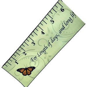 May include: A light green ruler featuring a monarch butterfly illustration and the text "For length of days, and long life". The ruler displays black measurement markings from 1 to 6 inches, with decorative swirling patterns printed across the surface.