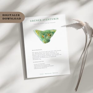May include: A white card with the text "DIGITALER DOWNLOAD" and "GRÜNER AVENTURIN" in green. The card features a green Aventurine stone and text describing its properties, including luck, growth, and renewal. A sprig of dried grass is in the background.