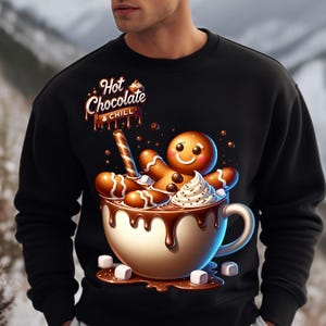 May include: A black sweatshirt with a graphic of a gingerbread man in a mug of hot chocolate. The text "Hot Chocolate & Chill" is above the mug.